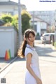 A woman in a striped dress is walking down the street.